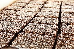 Chokoladekage med kokos skåret i stykker på fad